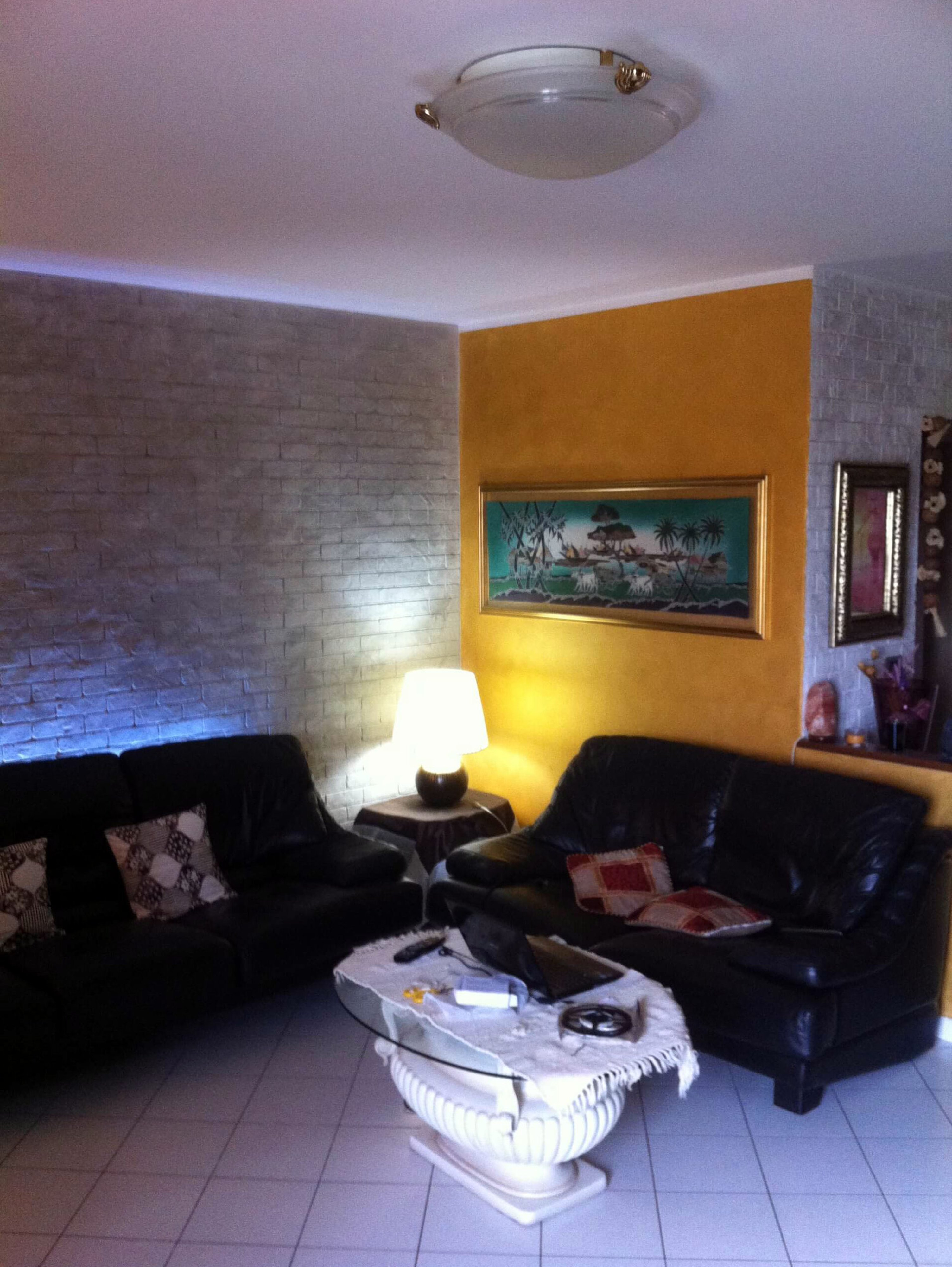 salotto con parete effetto mattone grigio argento