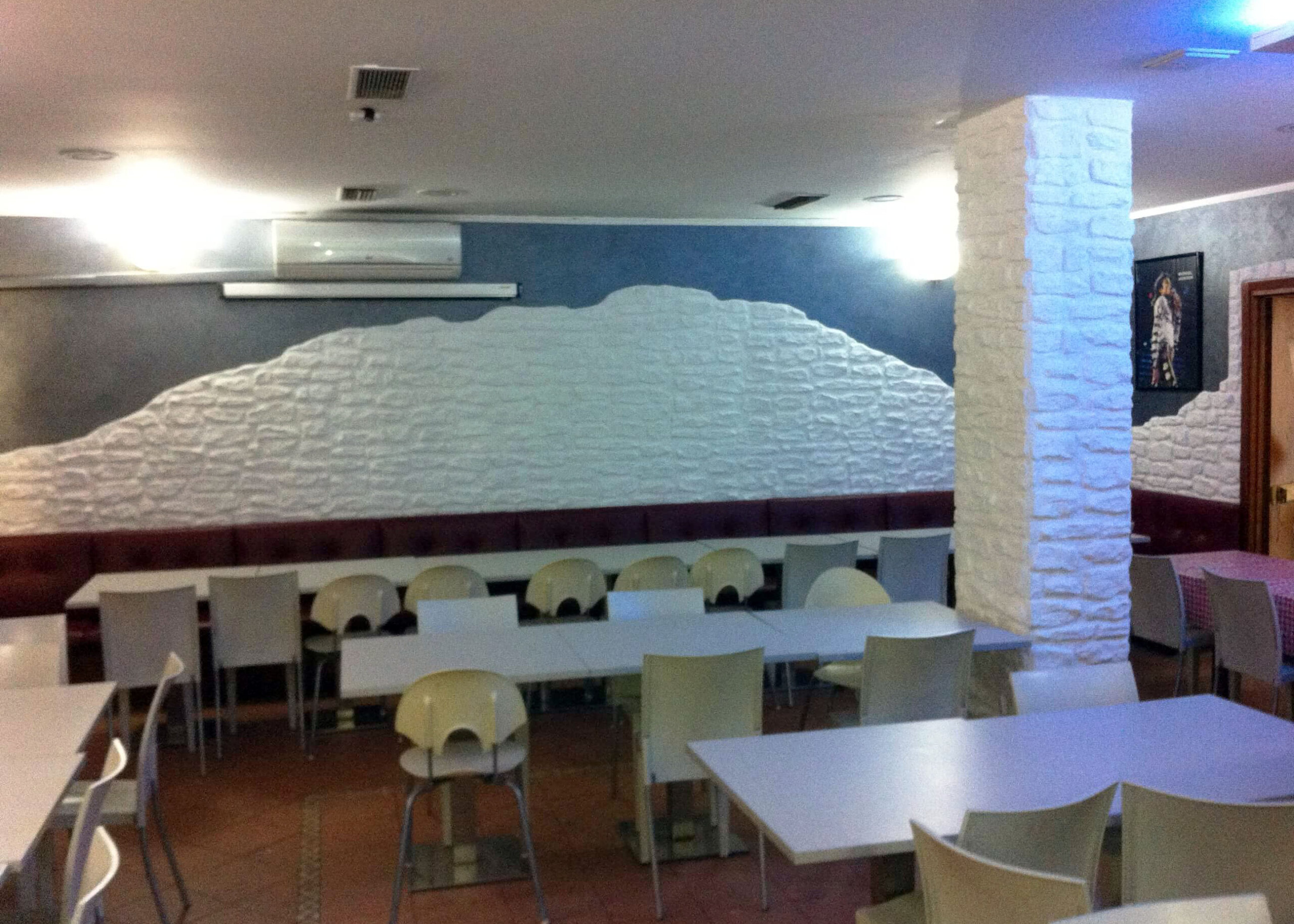 sala con parete blu e inserto in finta pietra bianca